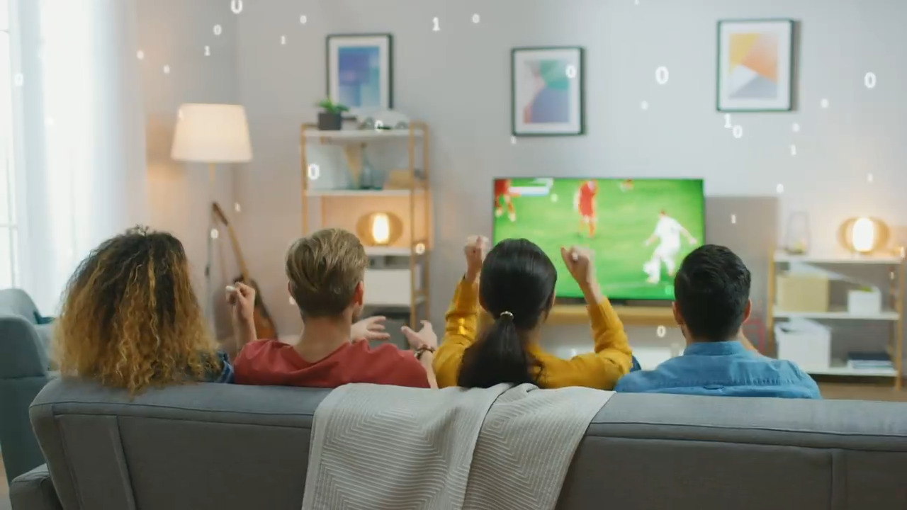 Vista trasera de cuatro personas sentadas en un sofá viendo un partido de fútbol con una superposición binaria de 1 y 0