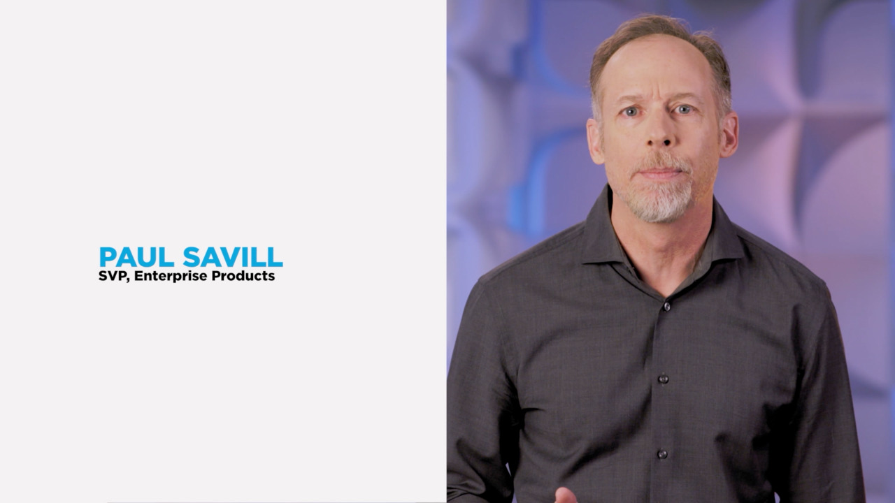 Close-up do empresário Paul Savill próximo a um fundo branco com seu nome e cargo