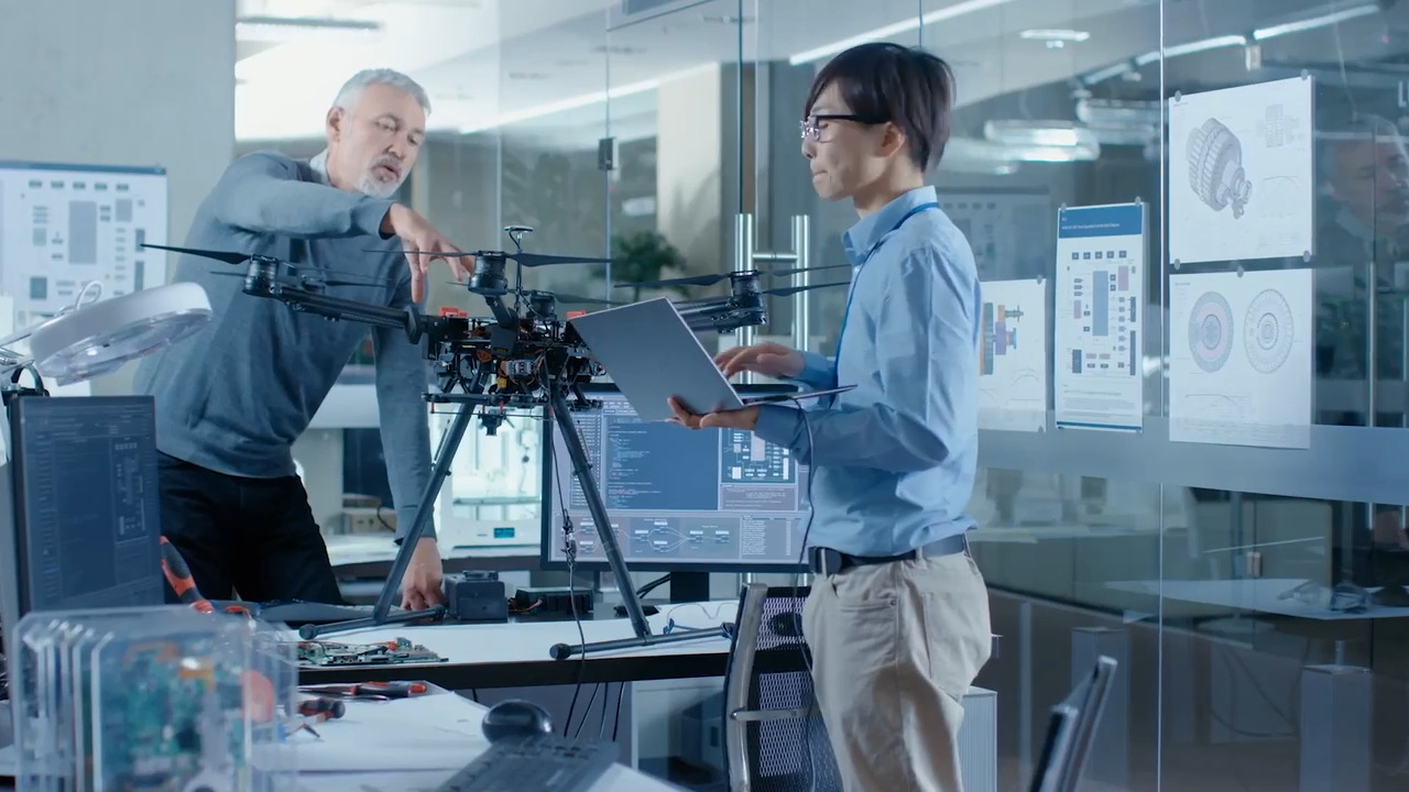 Two business men in an office working together on a drone