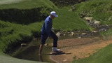 Hojgaard pulls off shoe and sock only to roll his shot back into water hazard