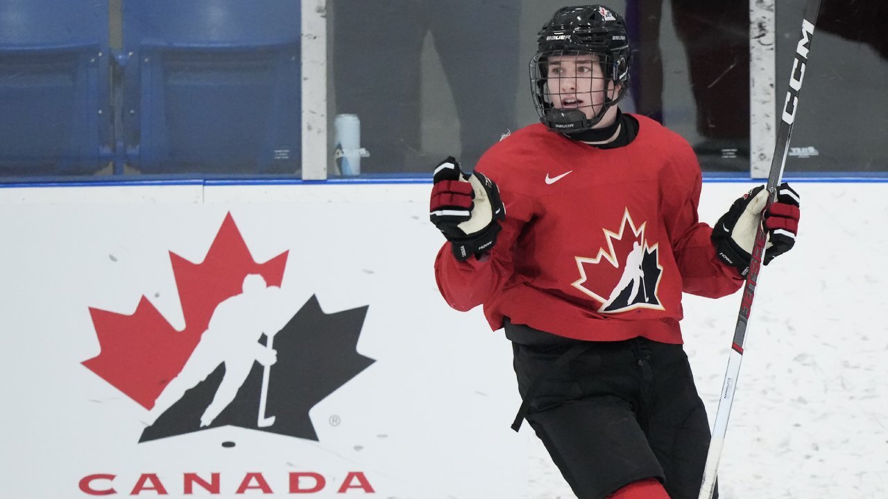 Connor Bedard and Macklin Celebrini discussing strategy with a Team Canada coach