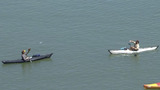 Couple of Giants fans in kayaks having a catch in McCovey Cove