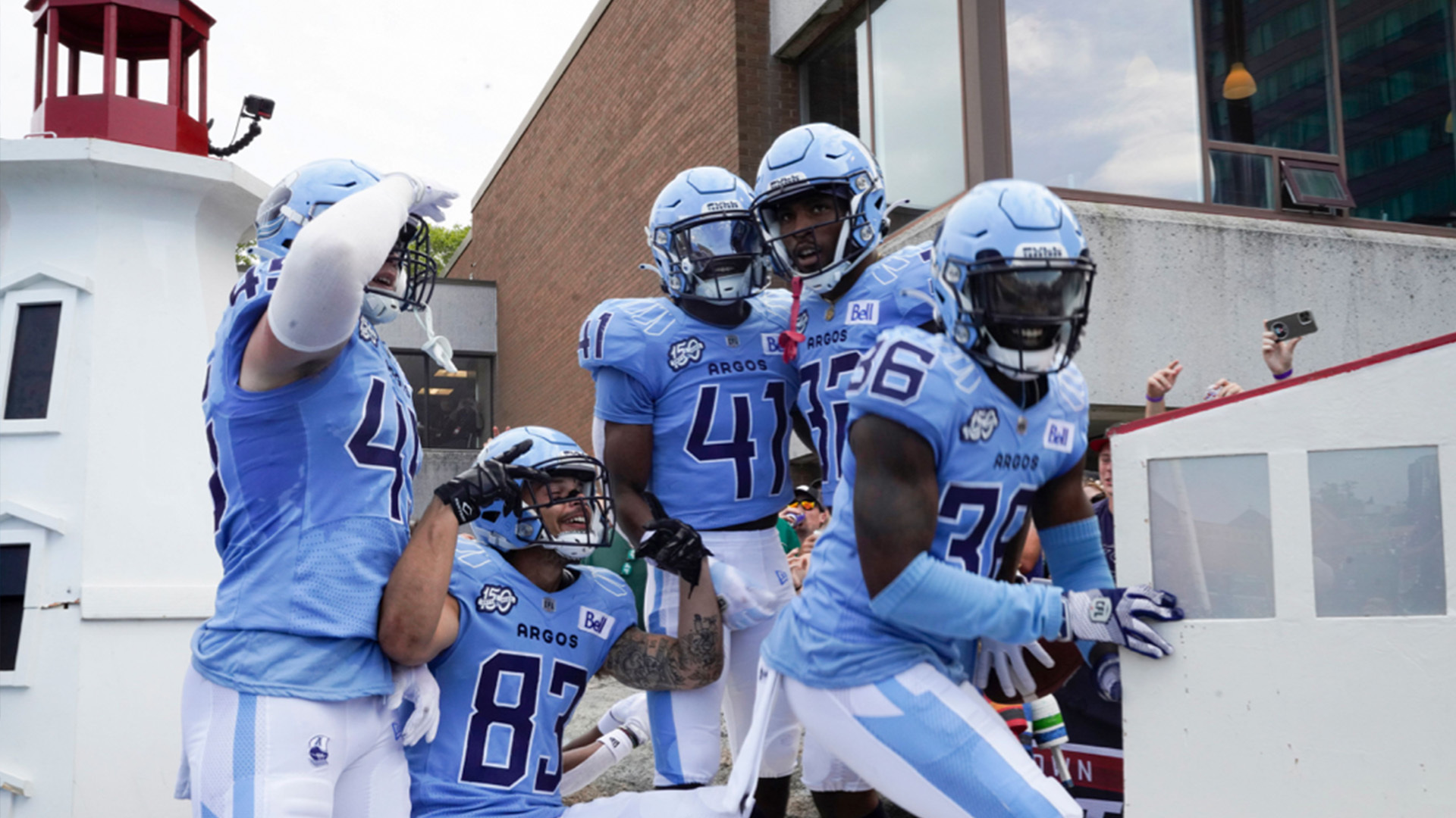 Toronto Argonauts running back Andrew Harris (33) is mobbed by teammates  after scoring a touchdown against the Montreal Alouettes during the first  half of a CFL Eastern Final football game in Toronto