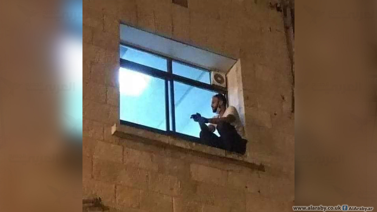 فلسطيني يراقب أمه المصابة بكورونا من نافذة المشفى إلى وفاتها