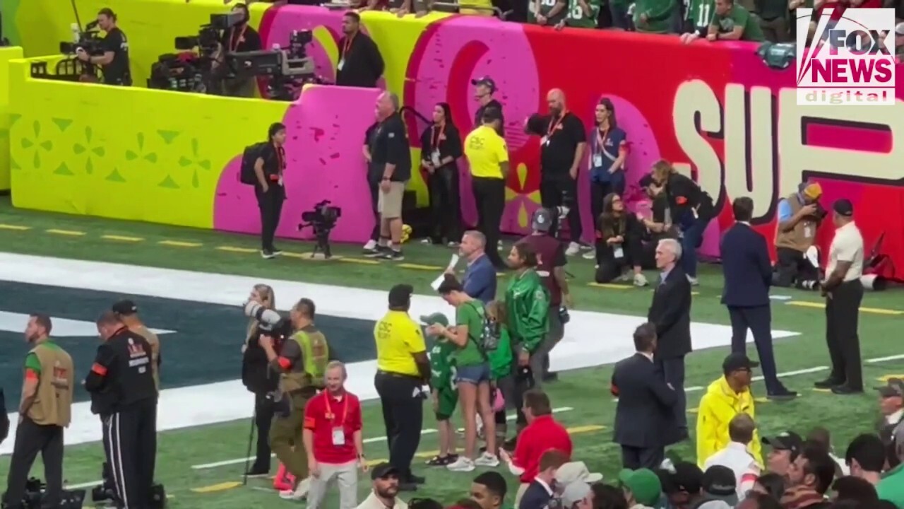 Bradley Cooper standing on the sidelines at the Super Bowl