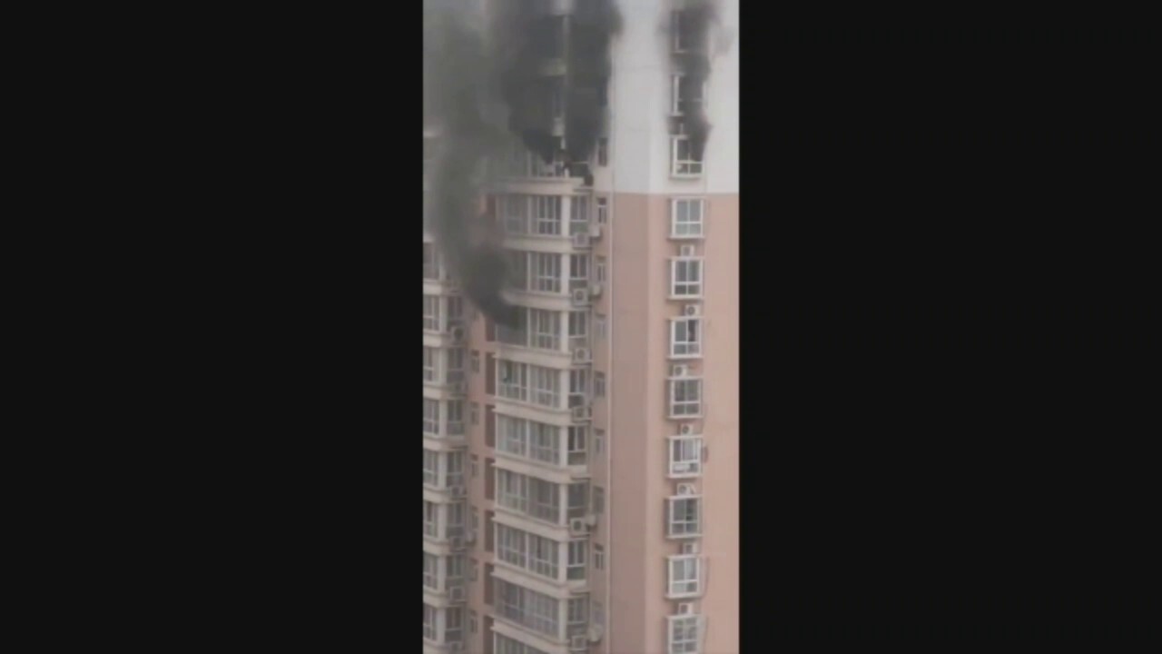 Video captures China residents clinging to ledge as fire rages in high-rise apartment building