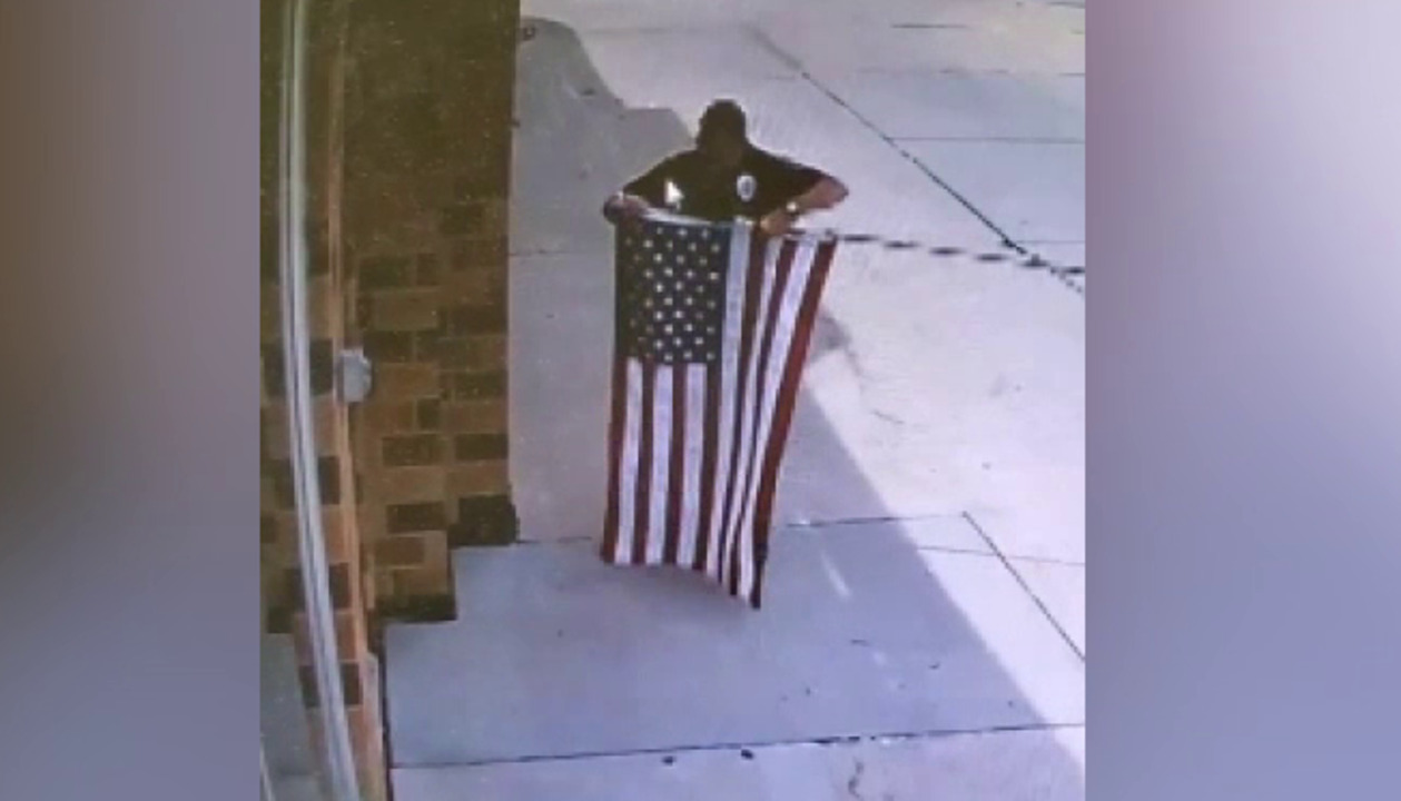 Raw Video: Police officer stops to fix fallen flag outside Nebraska business