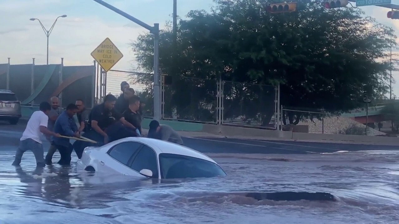 Woman rescued from car moments before it's swallowed by a sinkhole 