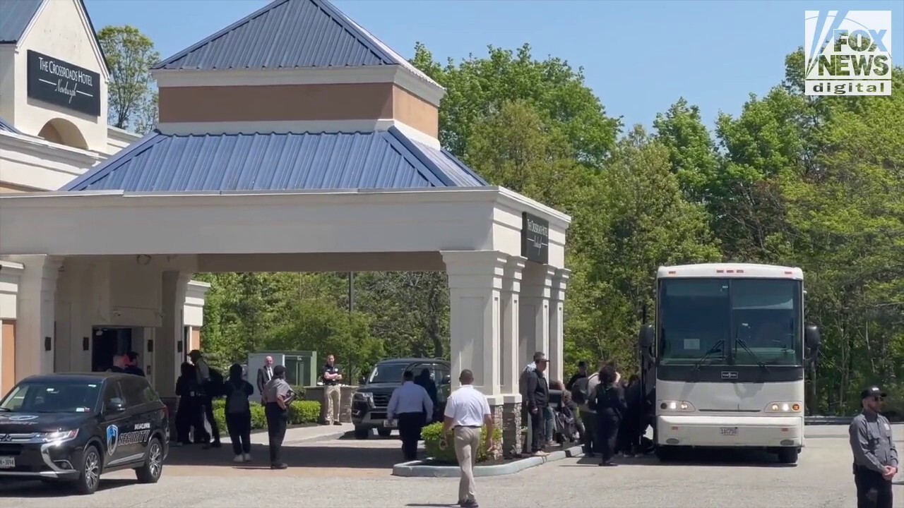 A second bus transporting migrants arrives at The Crossroads Hotel