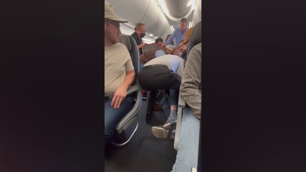Непокорен пътник на American Airlines, задържан от други, след като се опита да отвори аварийната врата по време на полет