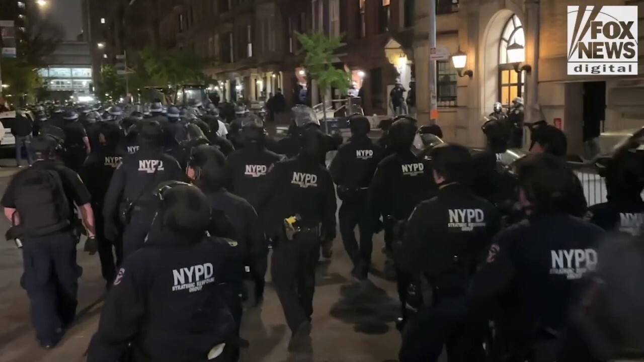 NYPD officers in riot gear move in on Columbia University where protesters have occupied building