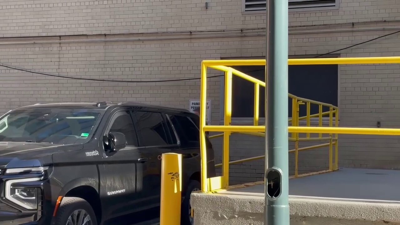 FBI agents load boxes into a car after searching John Bolton's DC office