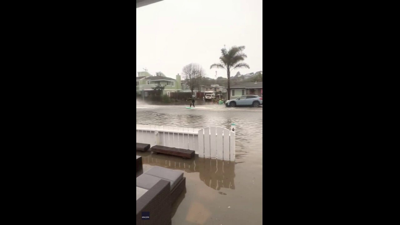 California man seen surfing behind a car after massive neighborhood flooding