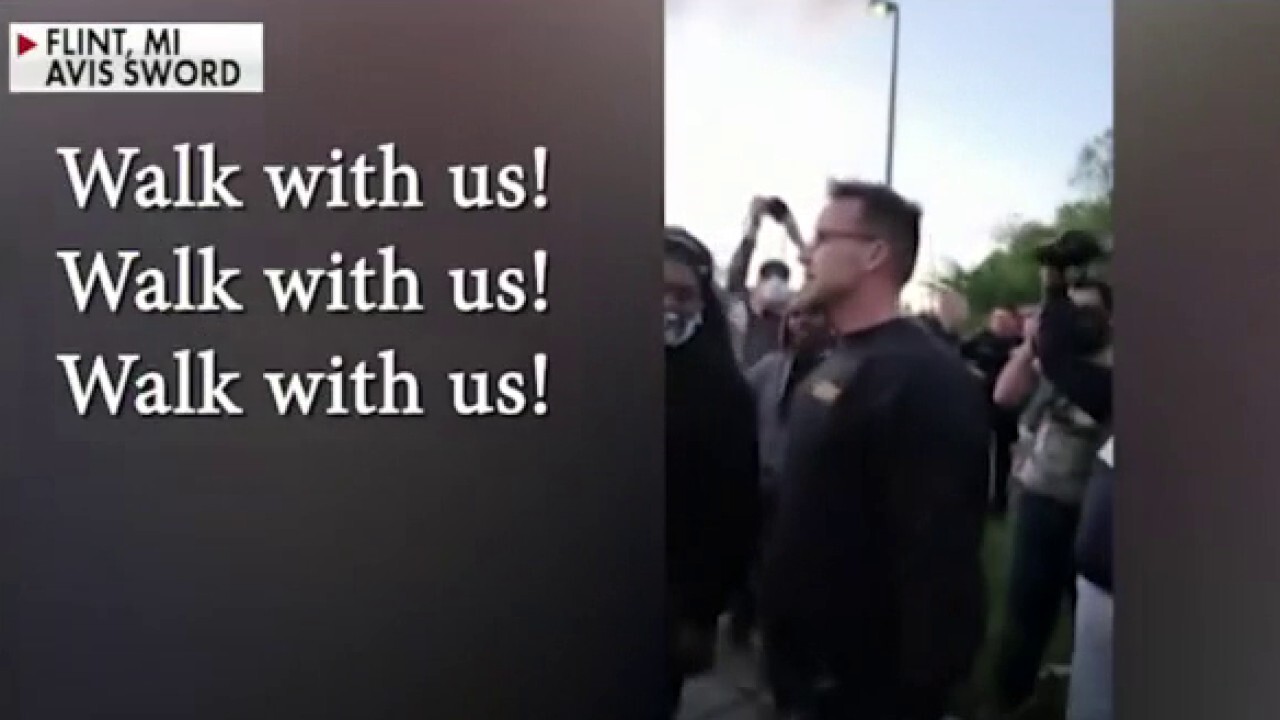 Michigan sheriff walks with protesters in effort to repair community relations	