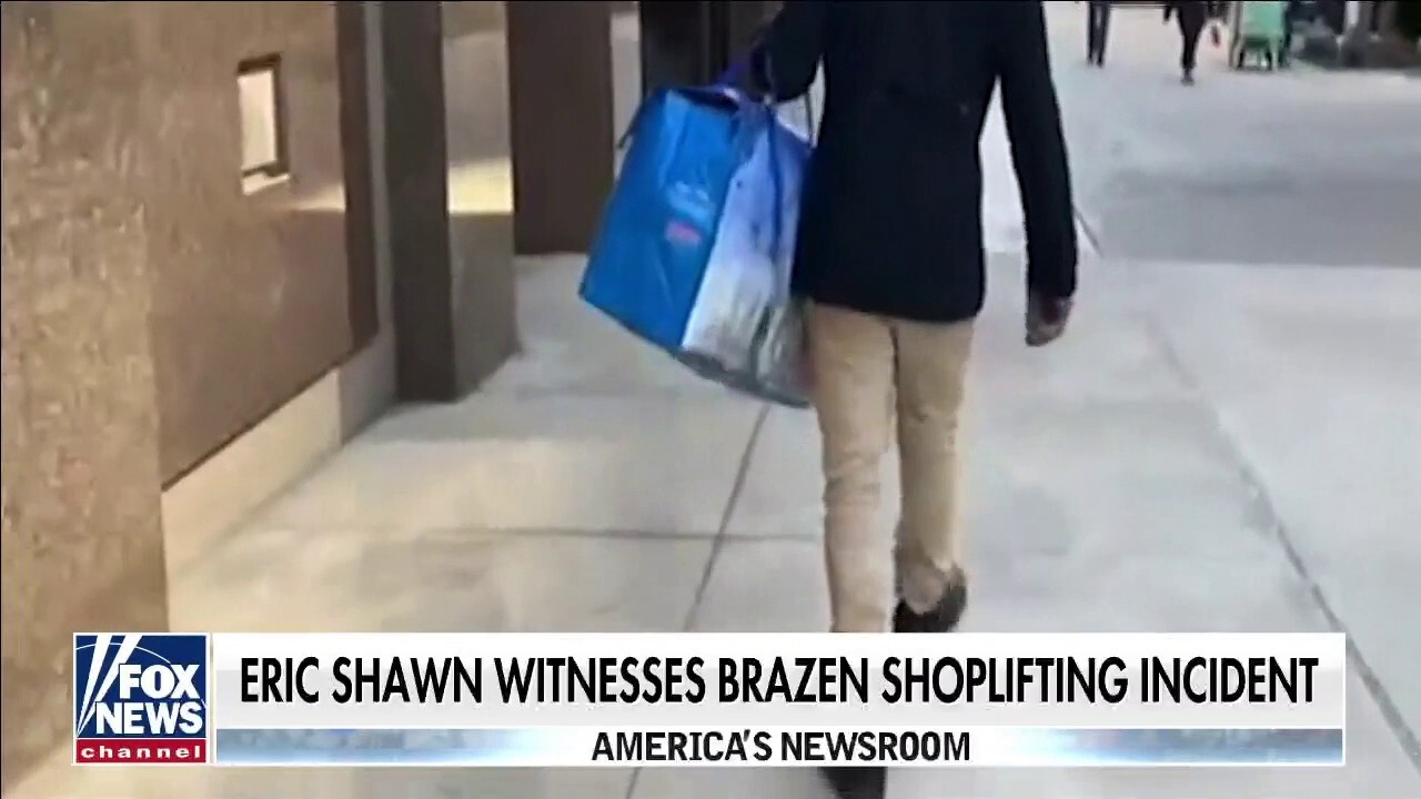 A man walks out of a New York City drugstore with a bag full of stolen goods in broad daylight.