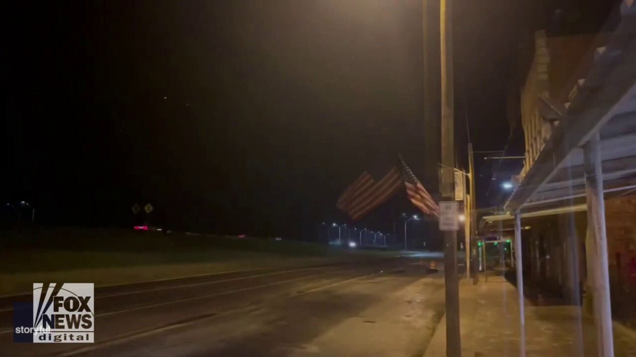 Lightning strikes light up the Texas sky as the American flag flies