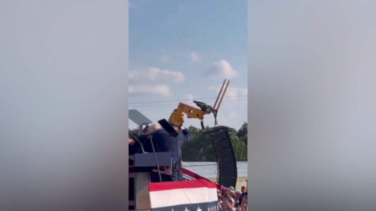 Former President Trump gives a thumbs up to the crowd while evacuating rally incident