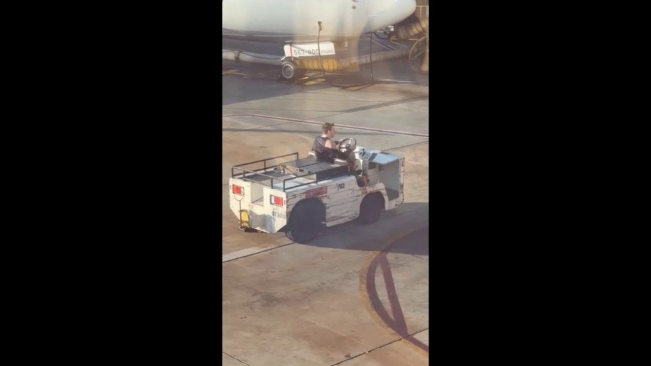 Wild video shows man driving stolen airport tug dangerously close to parked plane