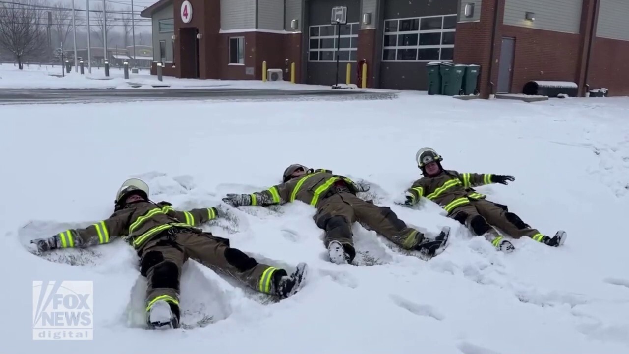 Firefighters take a break to make snow angels during winter storm