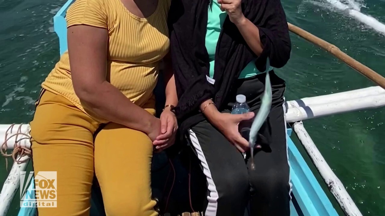Fish knocks woman's cellphone right out of her hand while on a boat