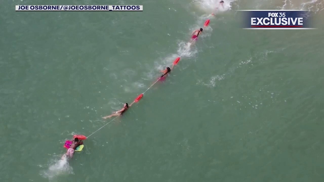 Florida lifeguards form human chain to rescue boogie boarder
