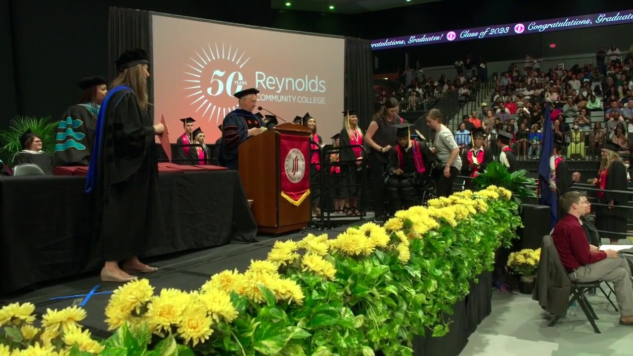 STANDING TALL: Paralyzed shooting victim walks at college graduation with the help of a robotic exoskeleton