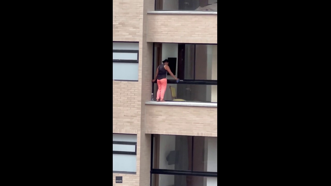On the edge: Watch a woman wash windows on a ledge of a high-rise building