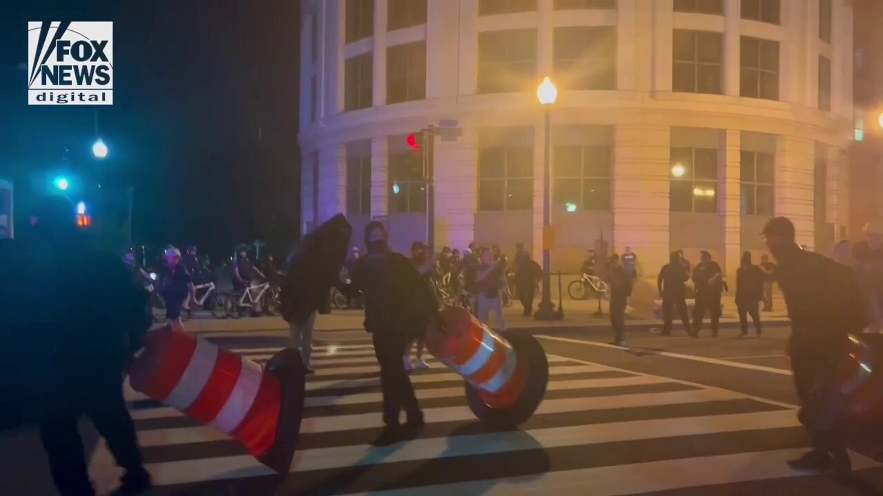 Protestors move traffic cones as they march through Washington D.C. following SCOTUS decision