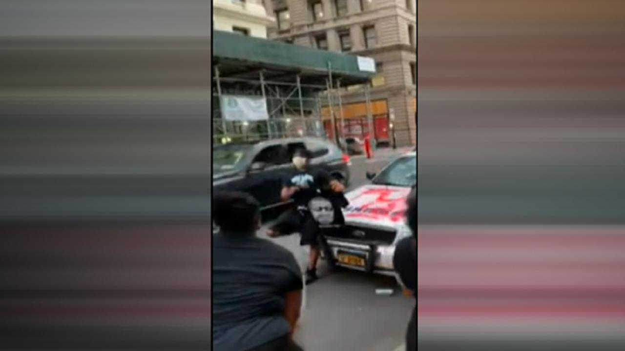 WARNING, GRAPHIC LANGUAGE: Protesters pose for pictures with vandalized NYC Sheriff squad car