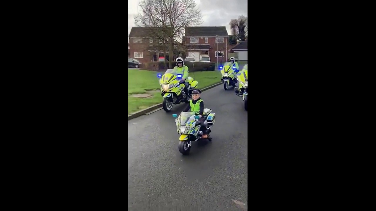 Watch this bereaved young boy lead a police procession on his new mini police bike