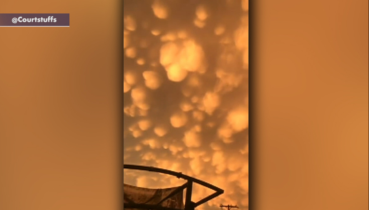 Glowing orange mammatus clouds cover the evening sky in Oklahoma after severe storm swept through