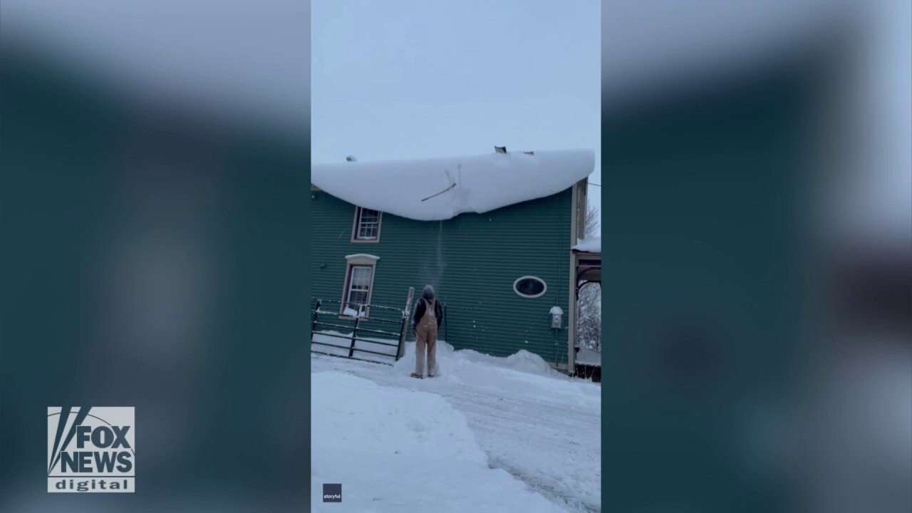 Man’s shovel gets stuck on snowy roof in comedic video