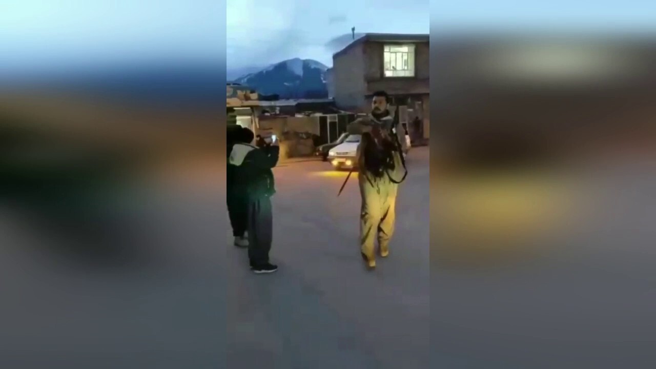 Men in apparent Kurdish military attire fire guns in Kurdish city