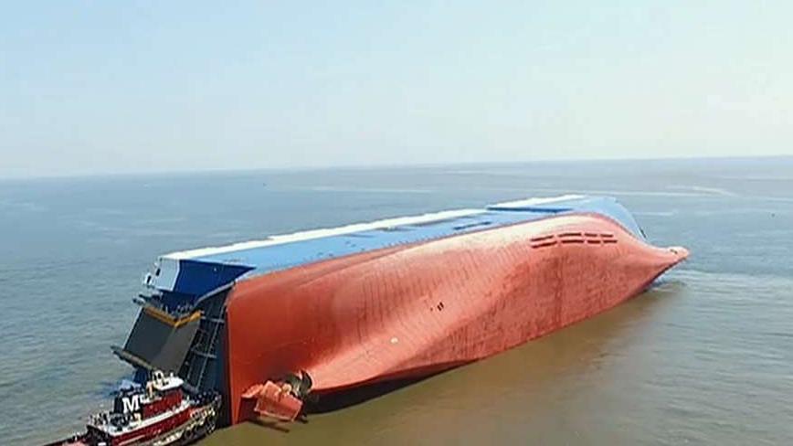 Coast Guard says 4 trapped crew members are alive on overturned cargo ship