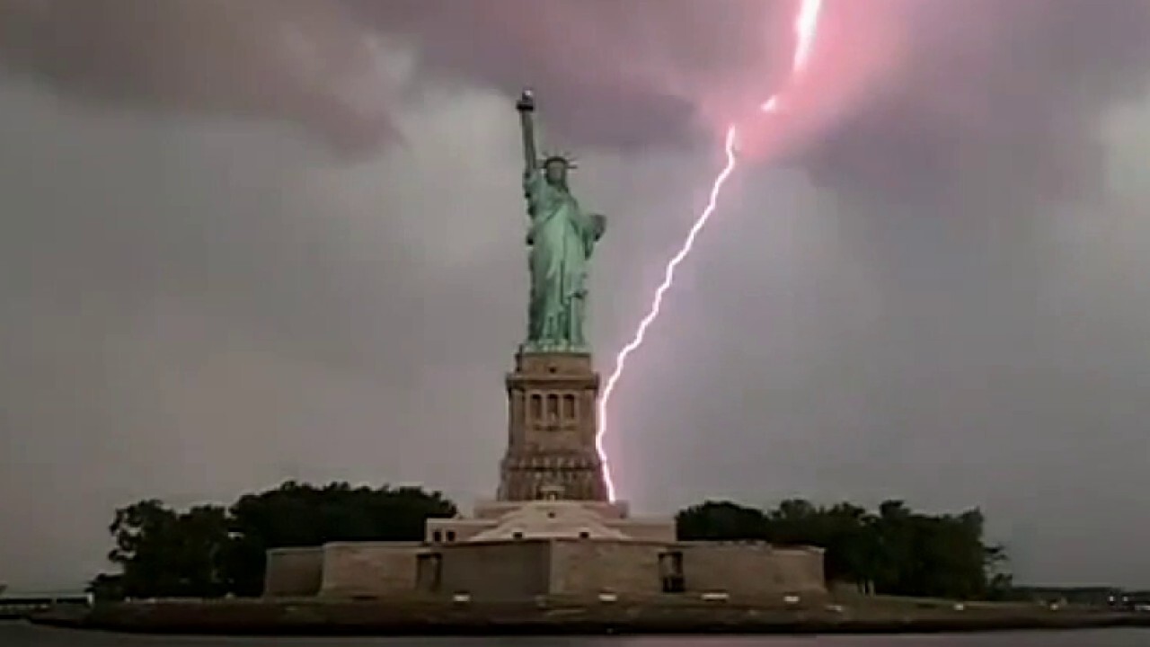 Lightning strikes behind the Statue of Liberty