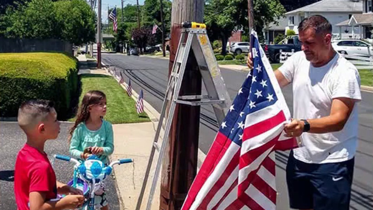 Community raises money to place hundreds of American flags throughout neighborhood