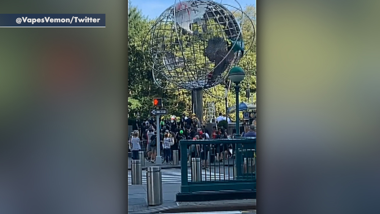Climate change protesters climb the Columbus Circle globe in NYC