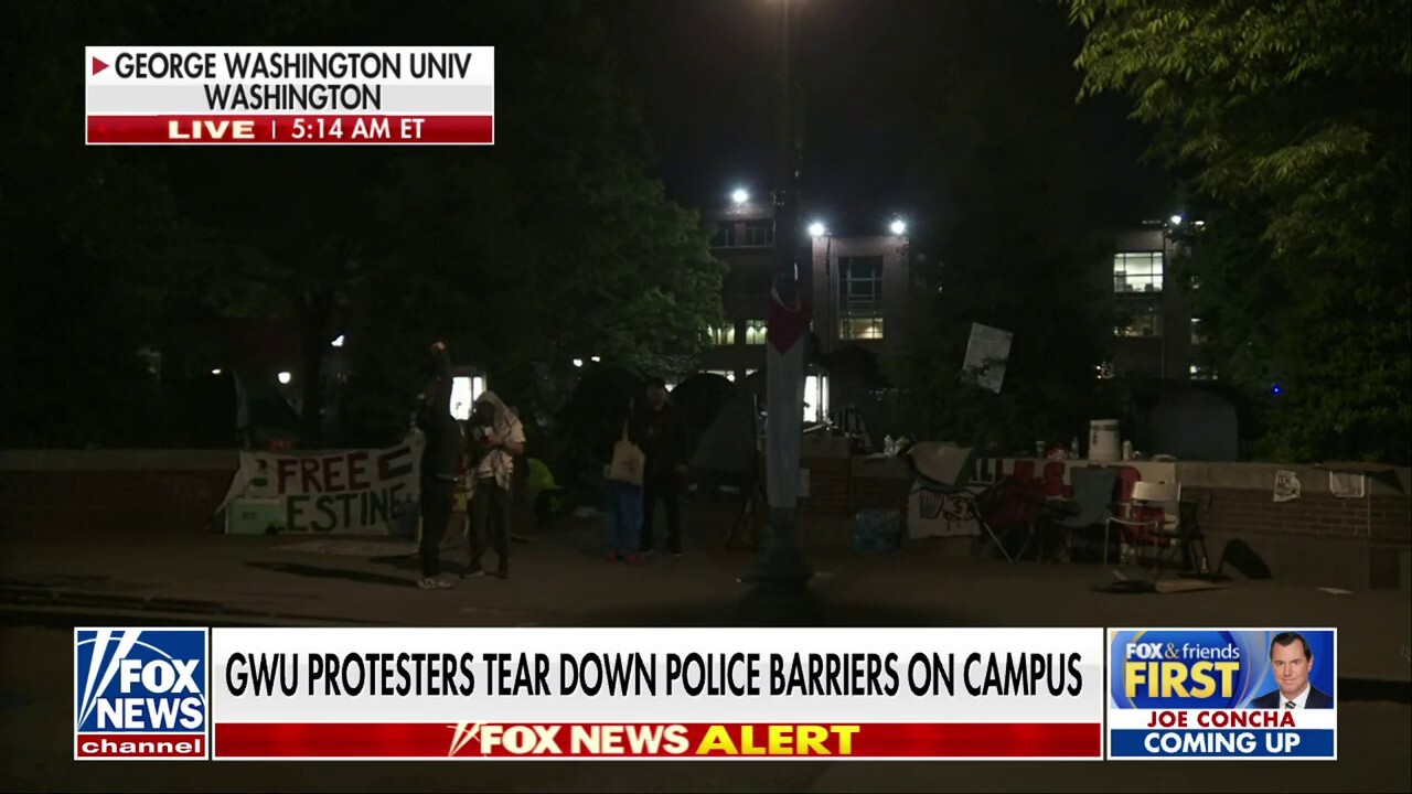 Protesters at George Washington University tear down police barriers
