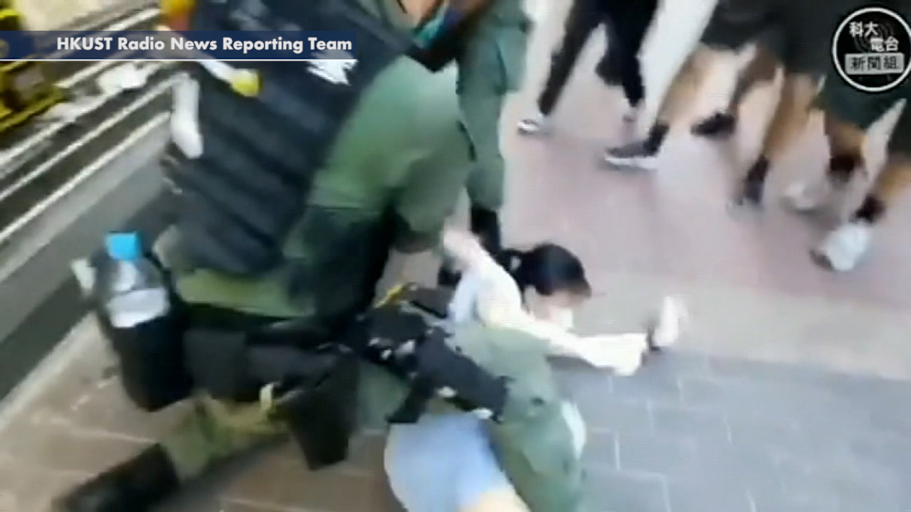 Police in Hong Kong tackle young girl to ground