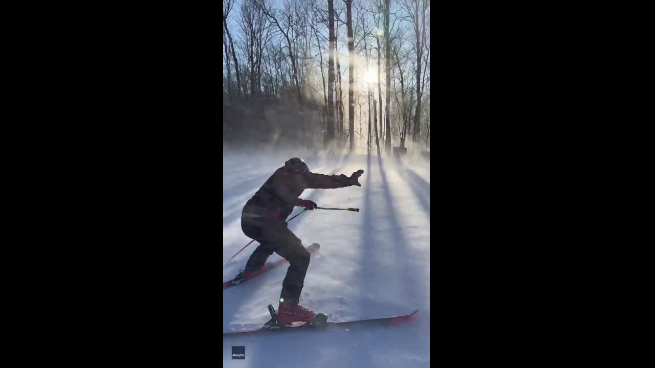 Skier is blown backwards by high winds on slope