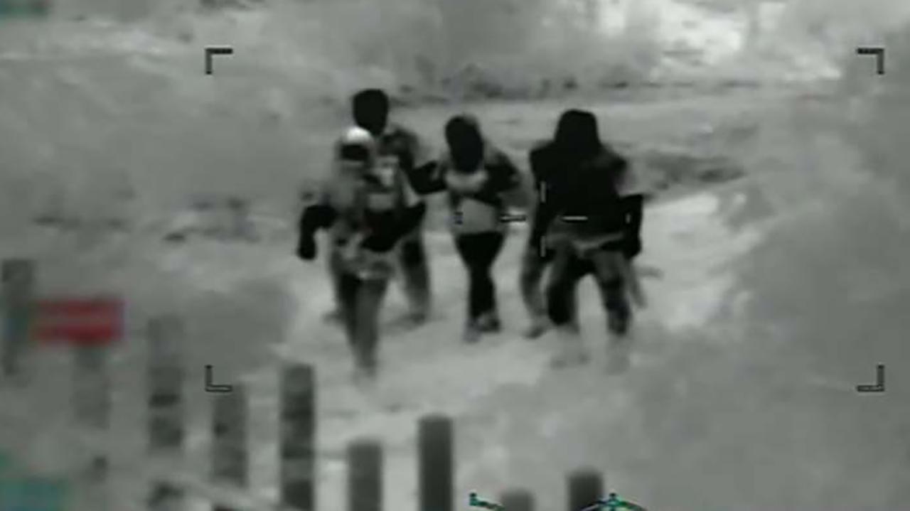 Smugglers with AK-47s escort migrants to border barrier, surveillance video shows