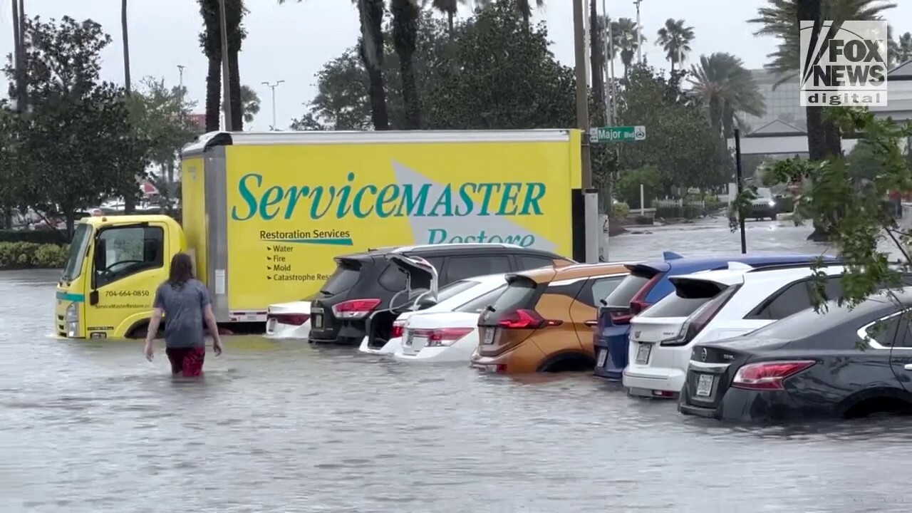 Universal Orlando guests wade through a parking lot during Hurricane Ian on Sept. 29, 2022. (Credit: Mom&Paparazzi for Fox News Digital)