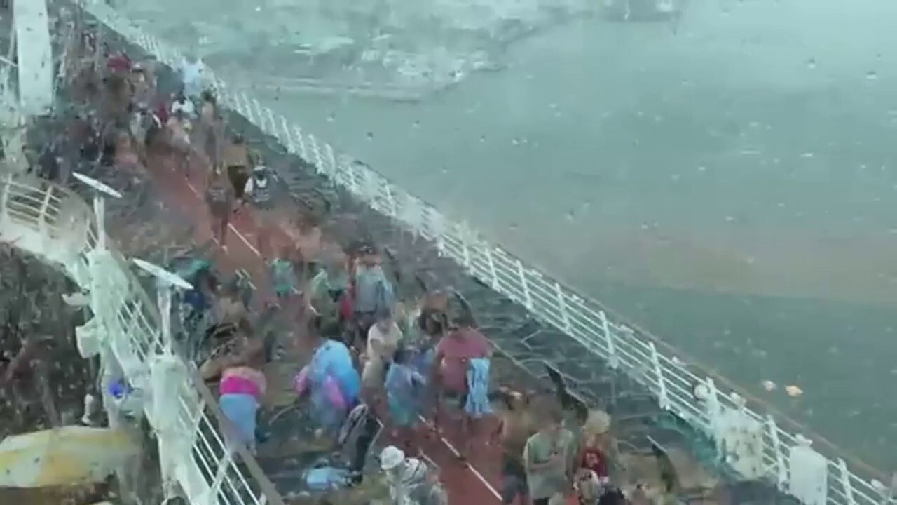 Passengers on a Royal Caribbean cruise ship were slammed with a freak storm ahead of their departure, forcing them to rush for cover as deck furniture was blown into the air. (Jenn Stancil)