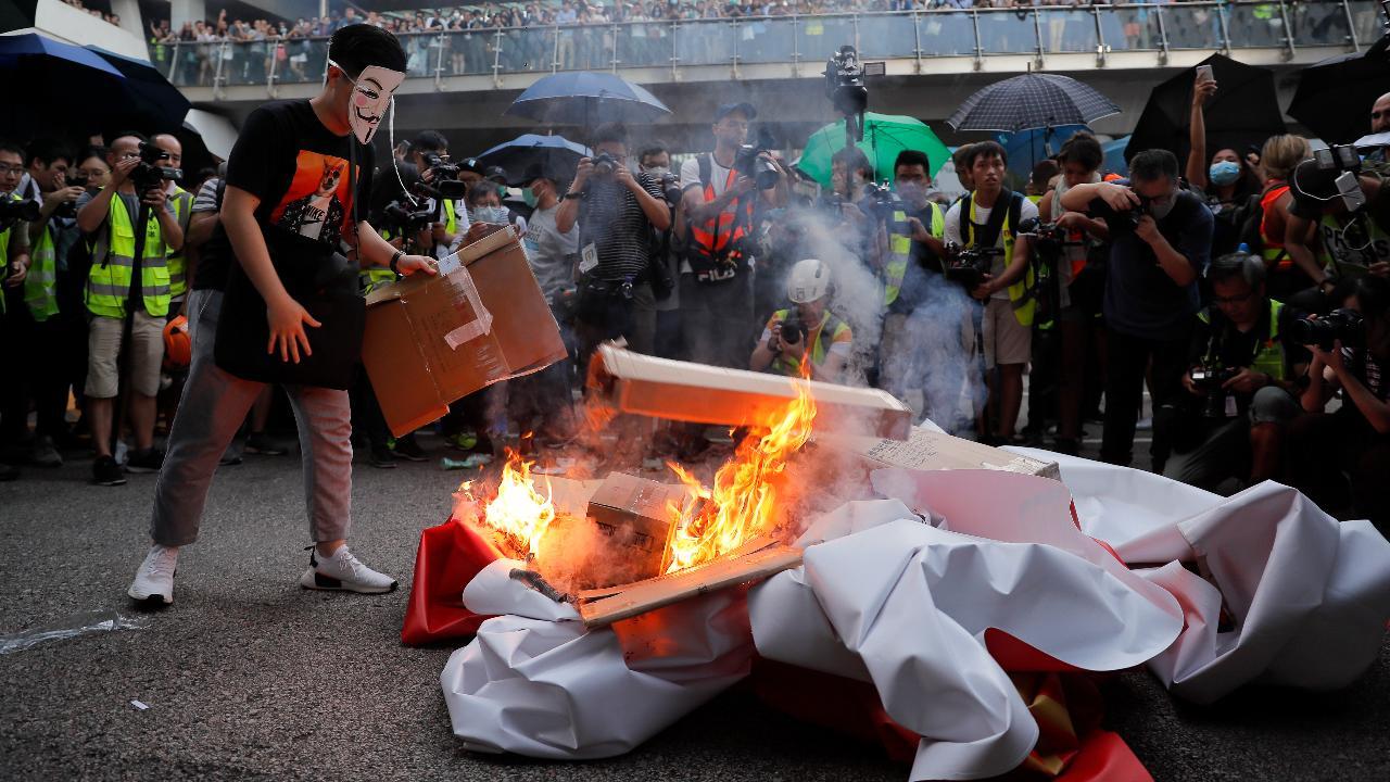 Protesters in Hong Kong defiant amid mask ban as hurled objects go up in smoke